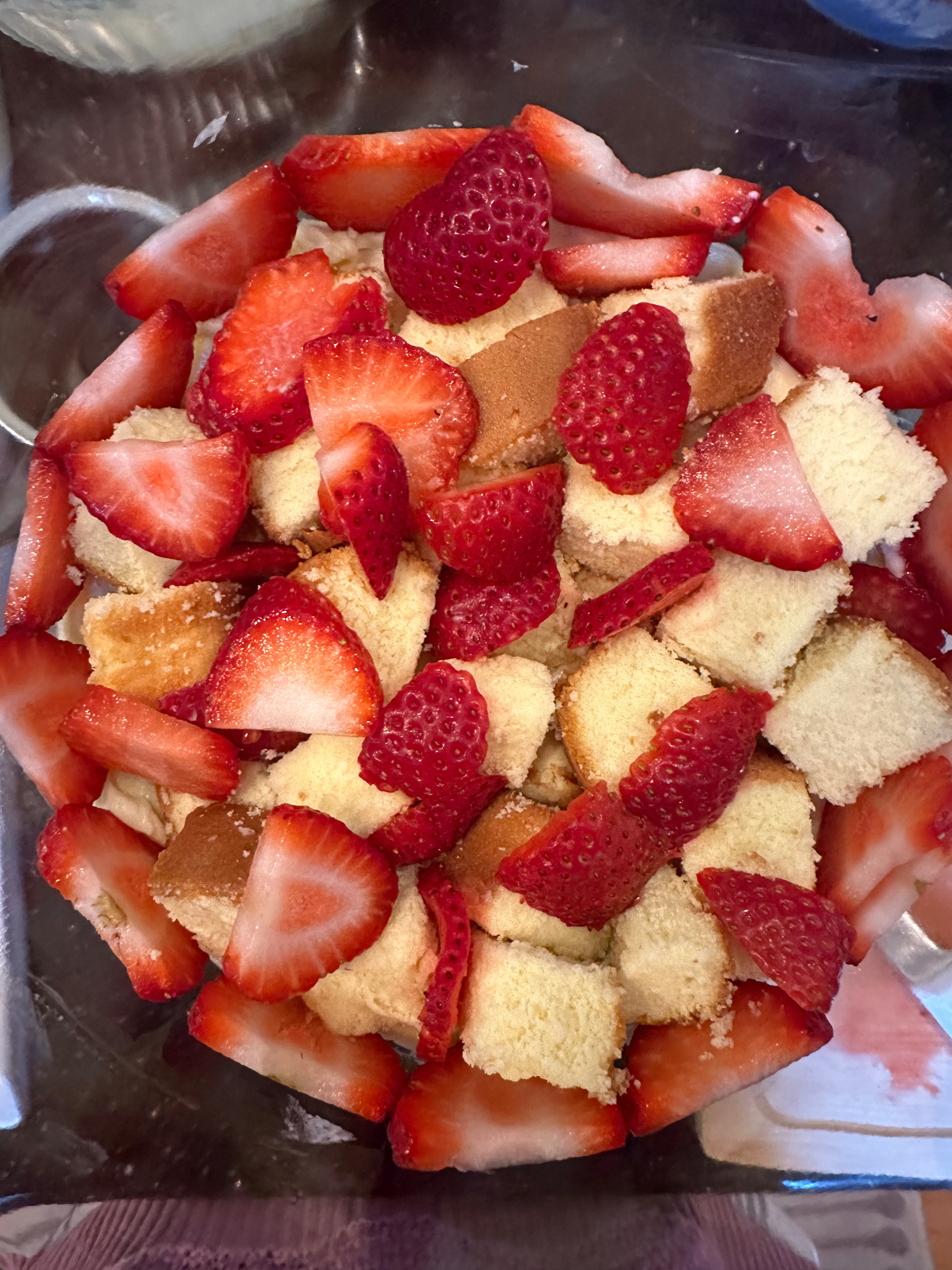 Layer the trifle with strawberries, pound cake, and cream