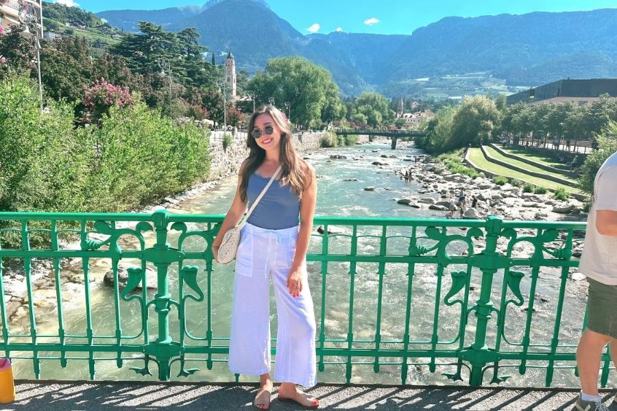 Ava standing in front of scenic river in Merano Italy