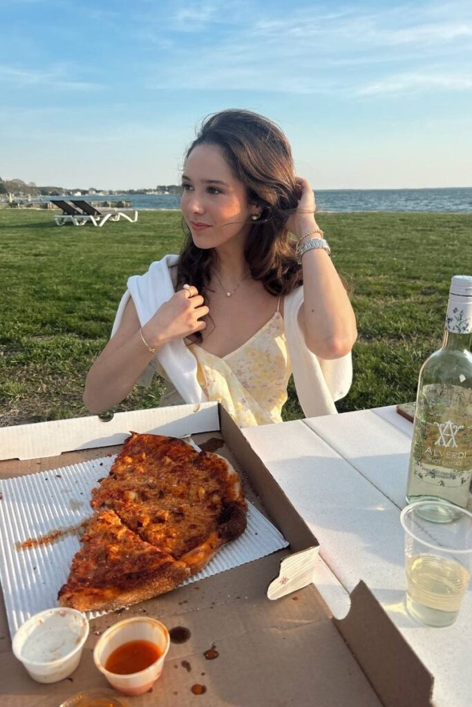 Camille eating pizza at Sandaway Suites & Beacch private beach