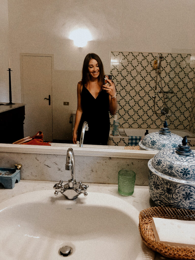 Ava taking a photo in a bathroom mirror in Tuscany Italy