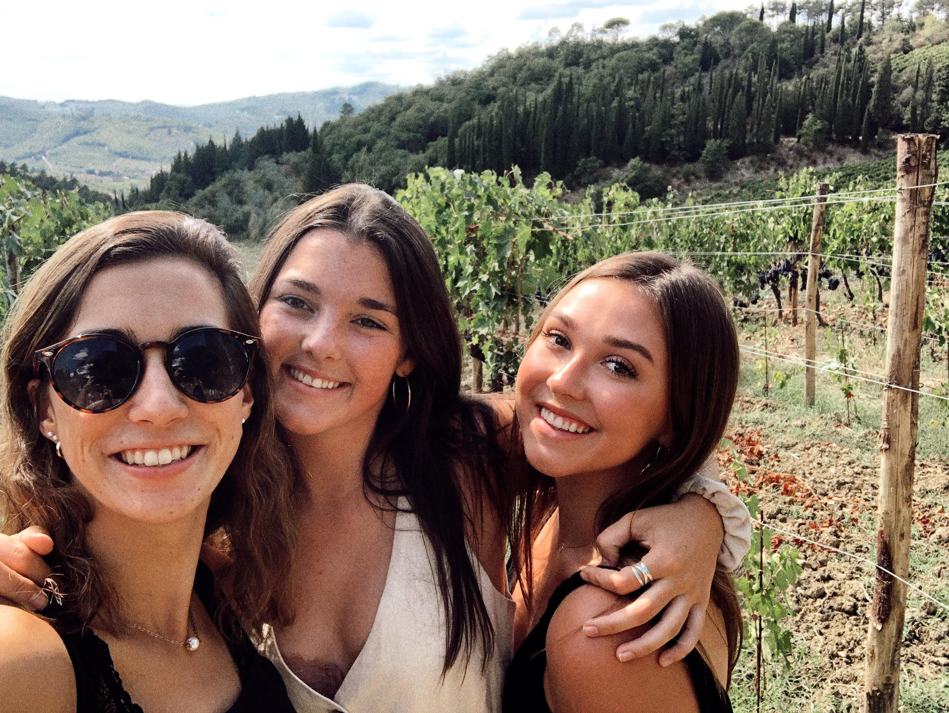 Friends taking a selfie in a vineyard at a winery in Tuscany Italy