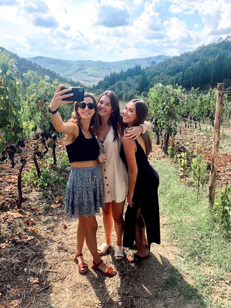 Three girls in a grape field in Tuscany Italy