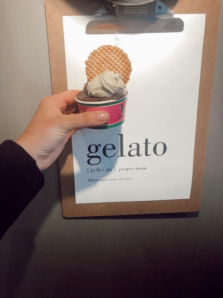 Gelato in front of a gelato sign in Florence Italy